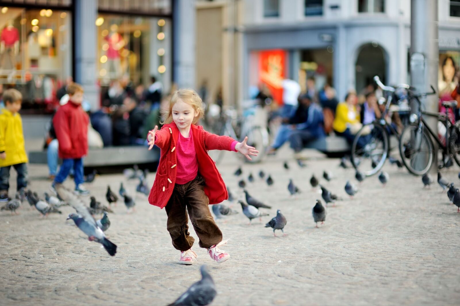 girl in amsterdam chasing birds - family trip to europe