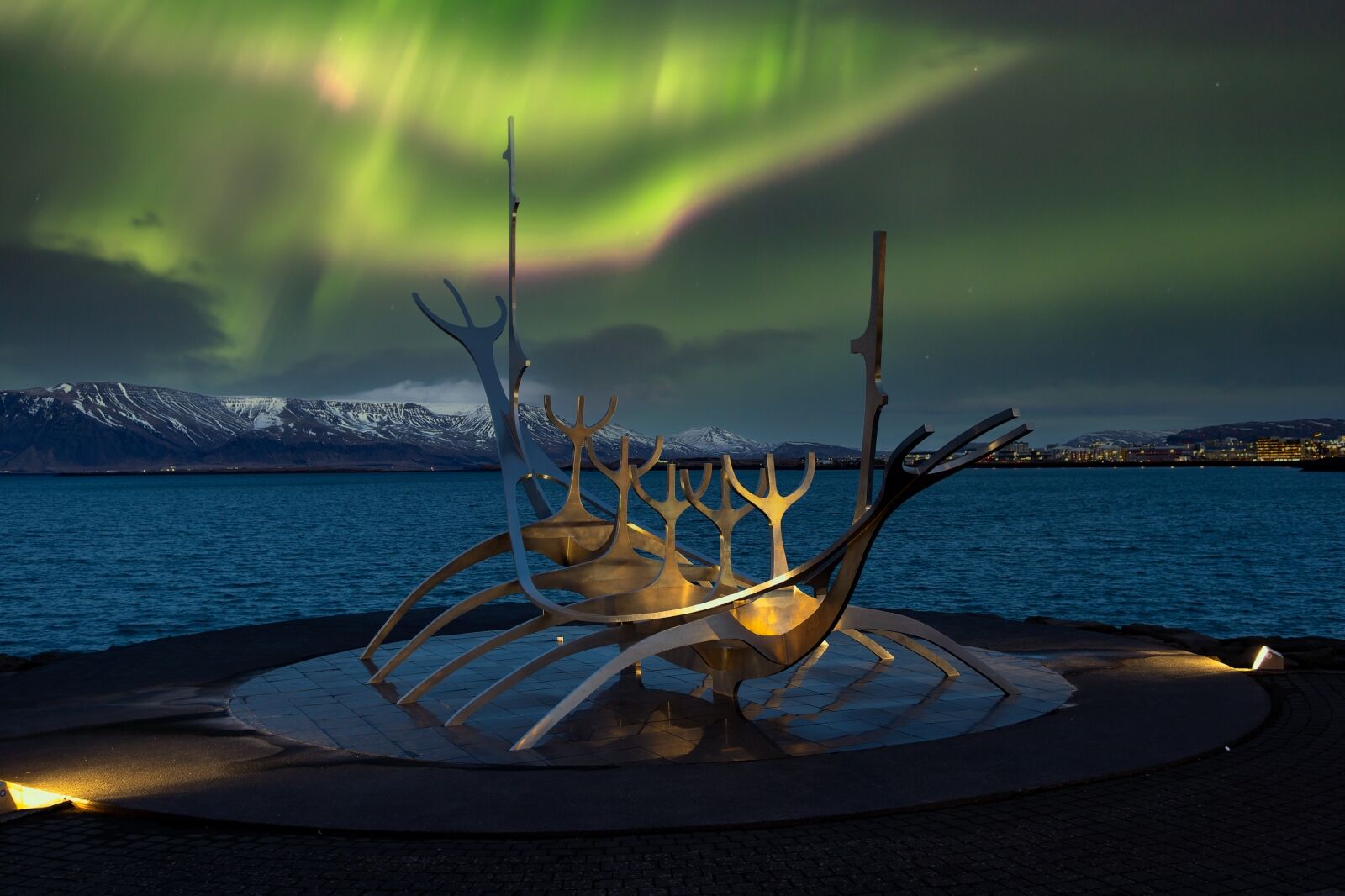 Metallic sculpture Sun Voyager in the Northern Lights. Aurora Borealis in downtown Reykjavik.