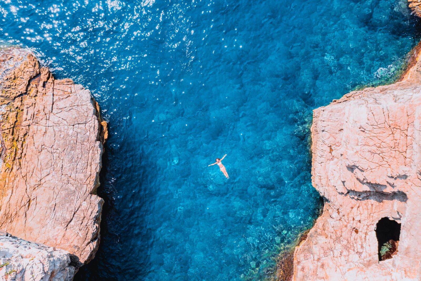 A woman swimming in the water with rocks in the background Croatia