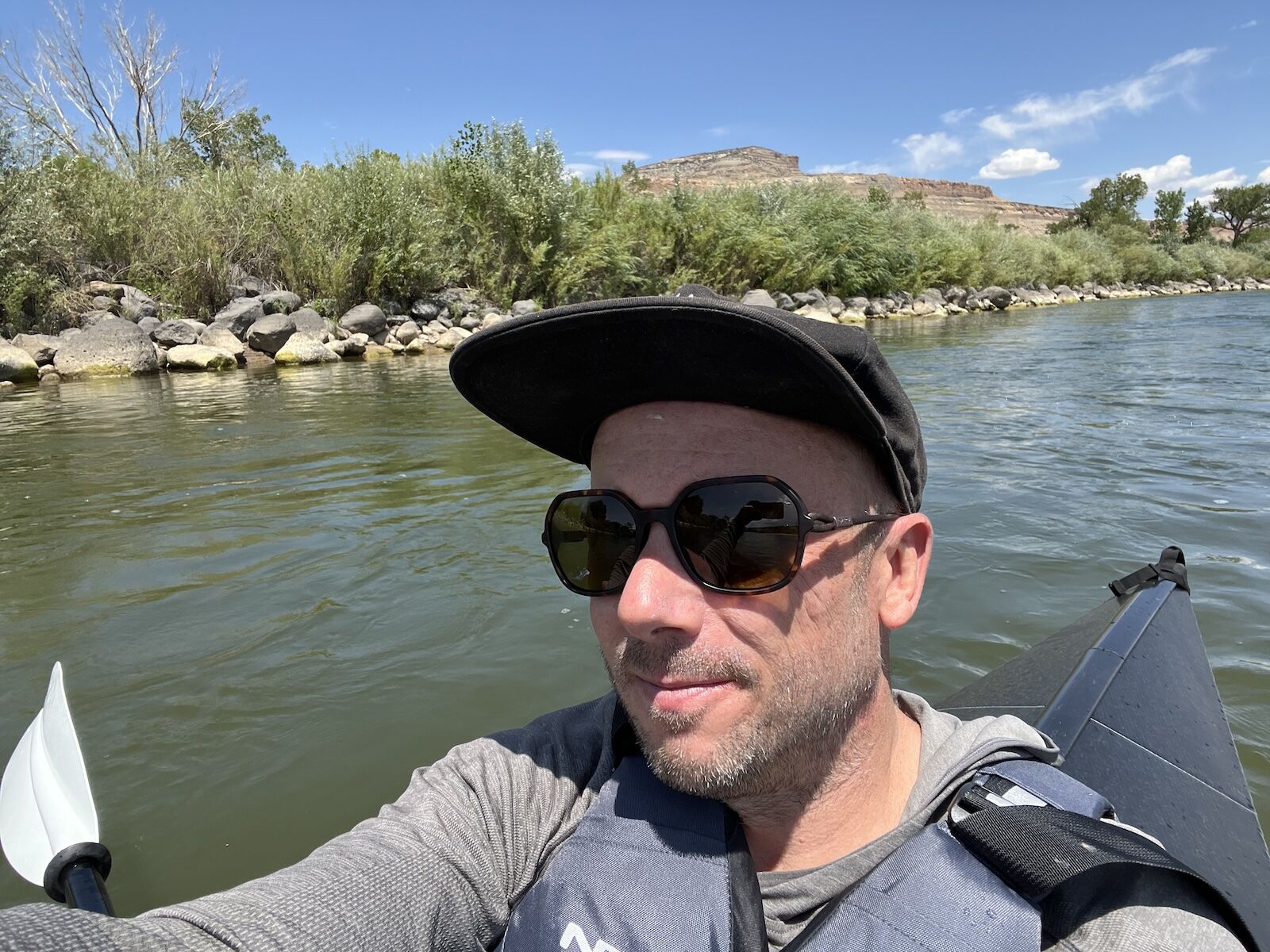 man in kayak wearing ombraz sunglasses