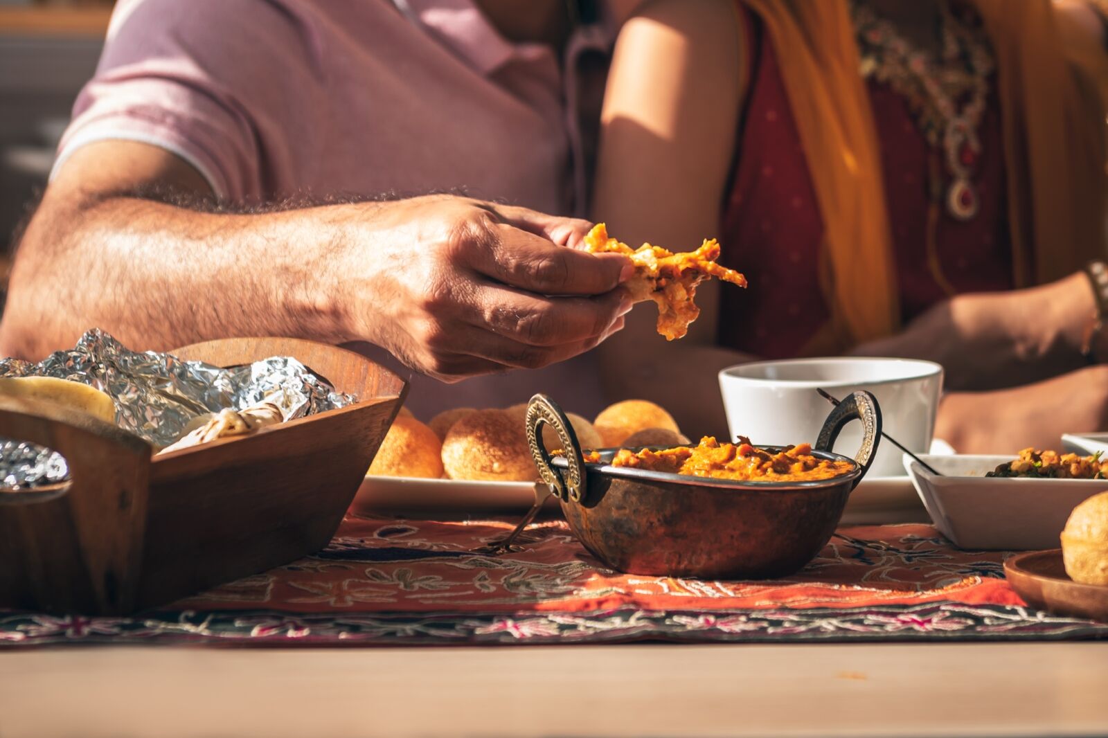 Close-up of Indian fathers hand Picking up Indian food, which is to food culture of Indians, to Indian family and food concept.