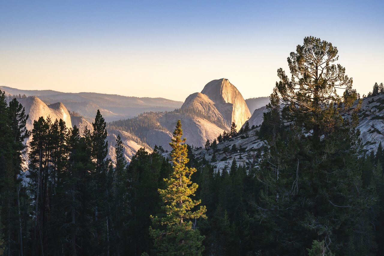 half dome in yosemite national park lit up by the sunset