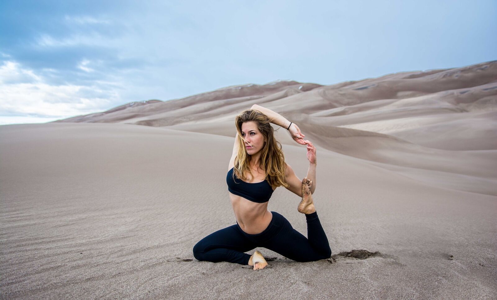 woman doing yoga on sand