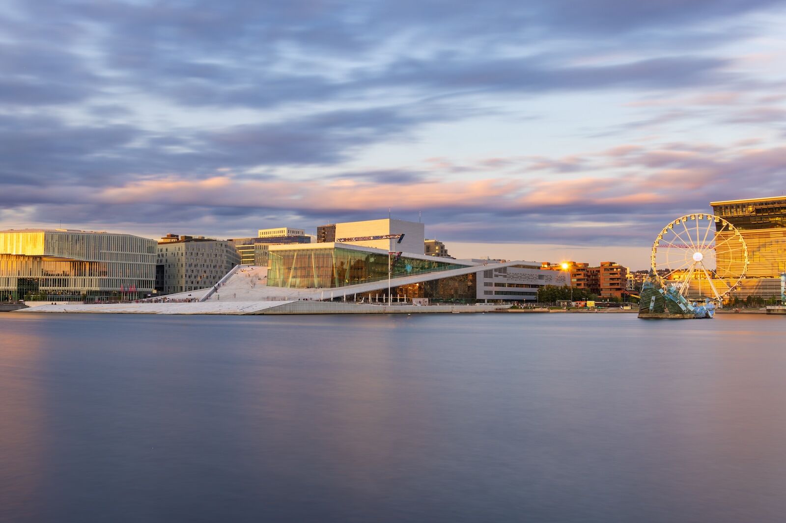 Oslo, Norway - August 2, 2024: Long exposure shot before sunset of the Oslo Opera House and the Munch museum along the Oslo Fjord in the Bjørvika area of the center of Oslo