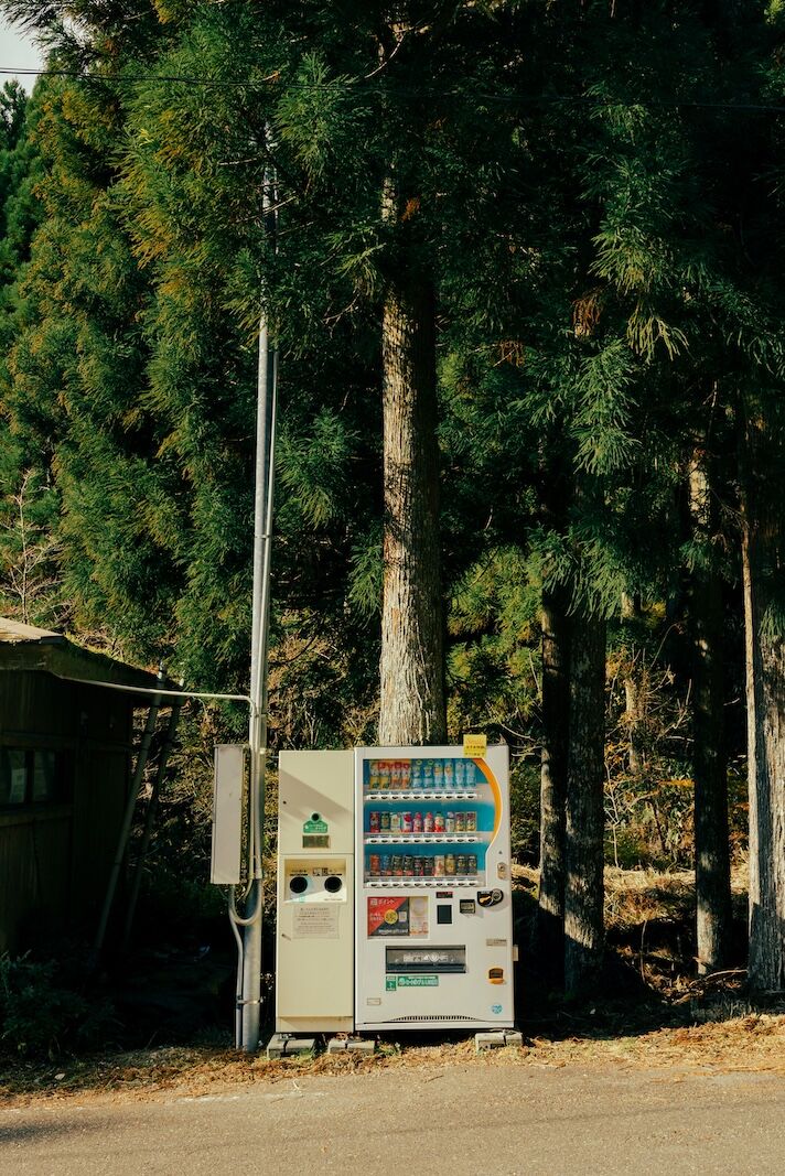 japanese vending machine in front of tree