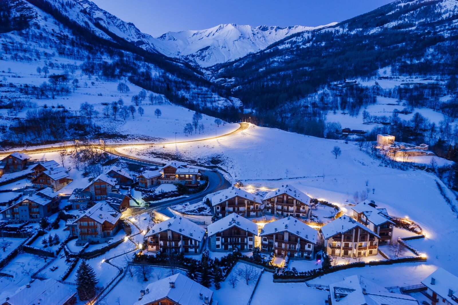 Panoramic view from above at nightfall of the snowy village of Bardonecchia, a ski resort in the Alps in Piedmont, Italy.