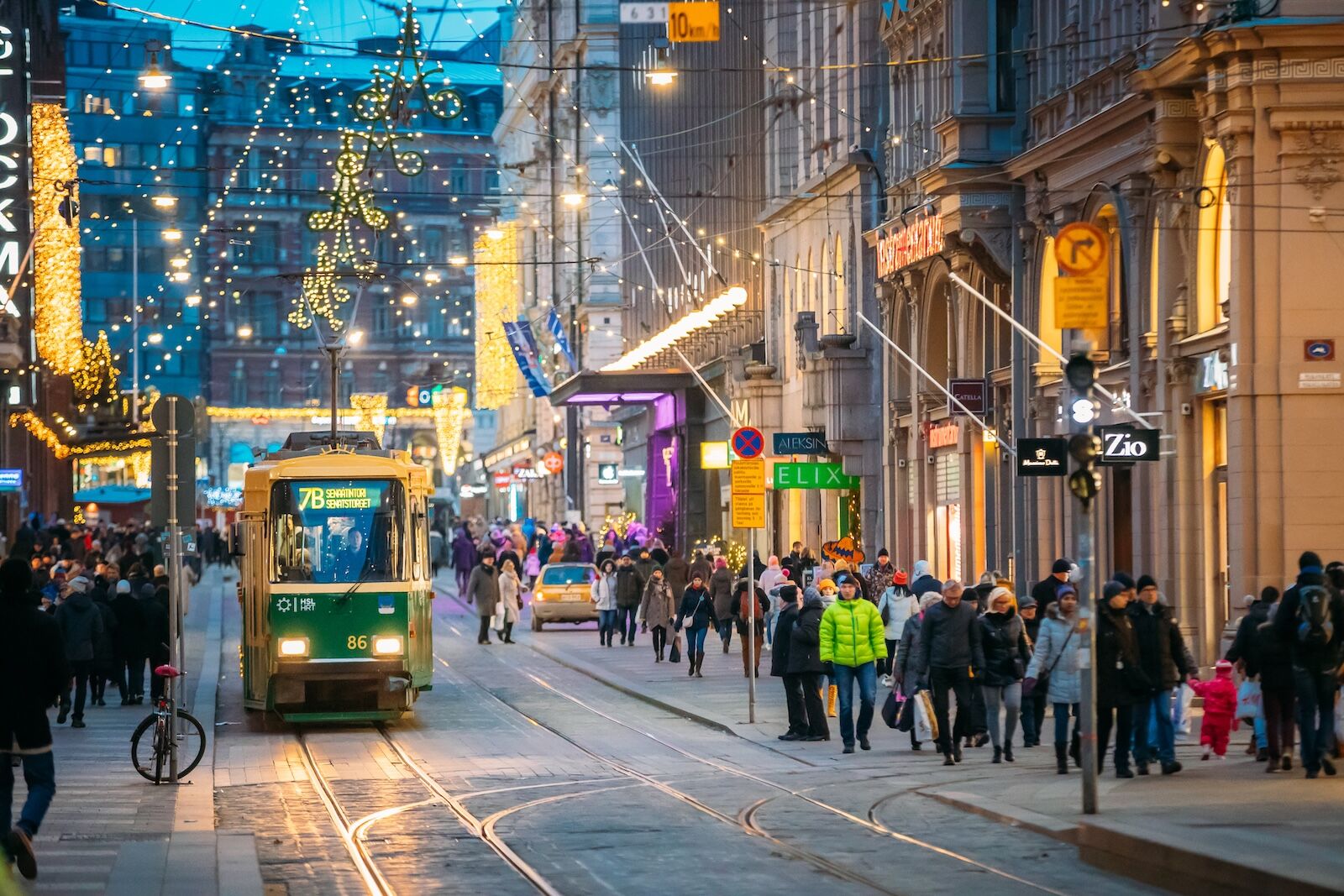 Helsinki, Finland - December 11, 2016: Tram Departs From Stop On Aleksanterinkatu Street. Street With Railroad In Kluuvi District In Evening Or Night Christmas Xmas New Year Festive Illumination