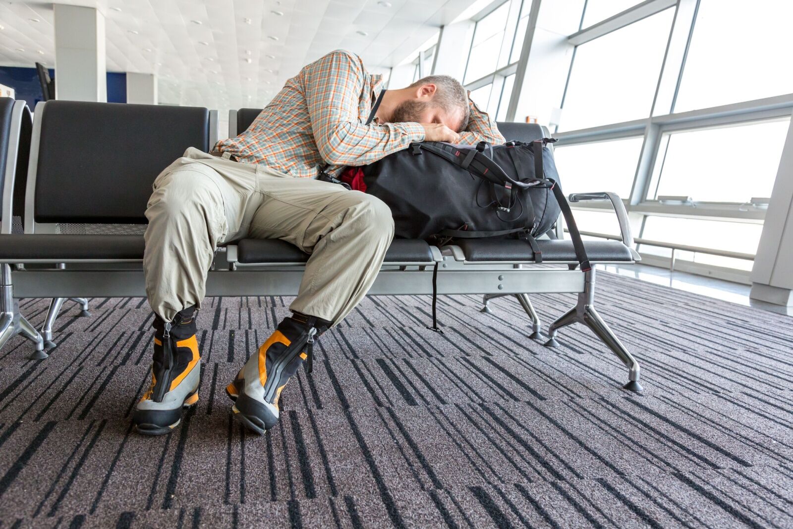 guy sleeping in airport chair