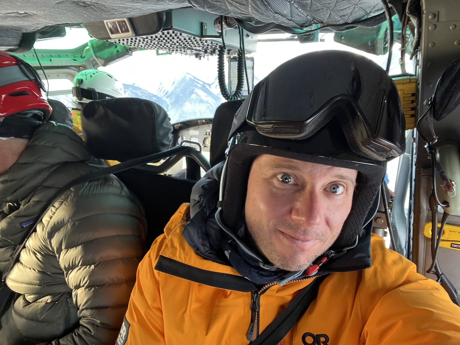 man riding in helicopter with ski gear