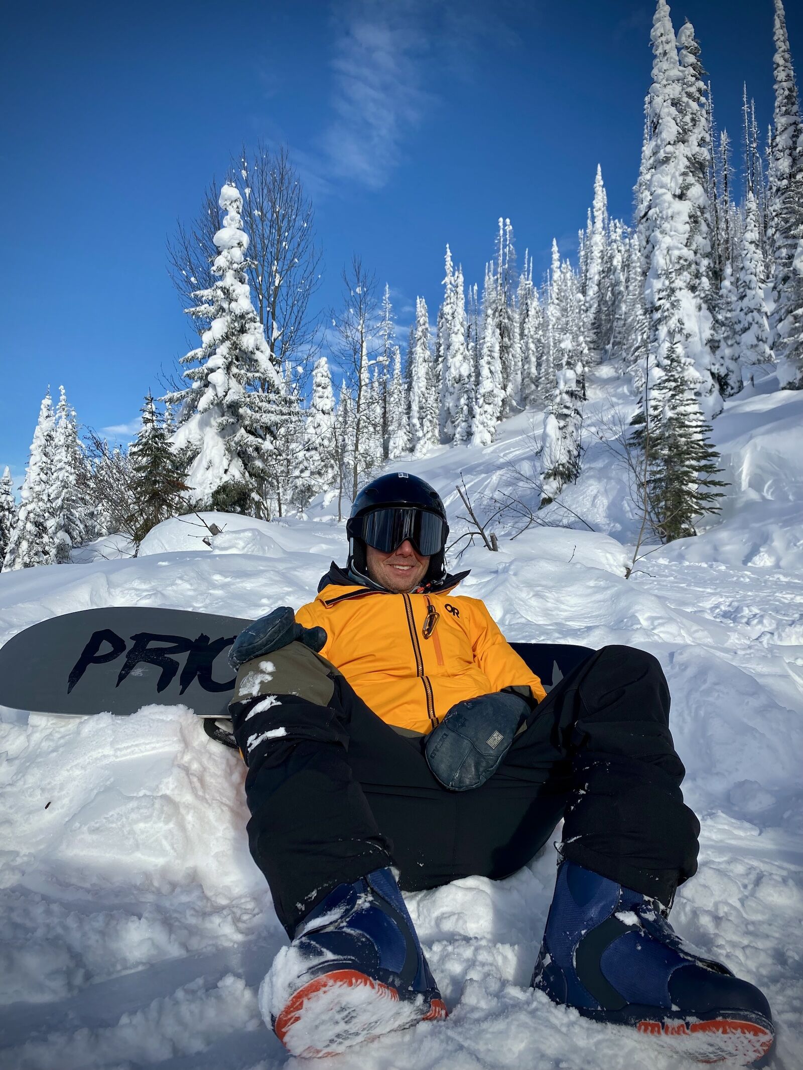 man in snowboard gear sitting in snow