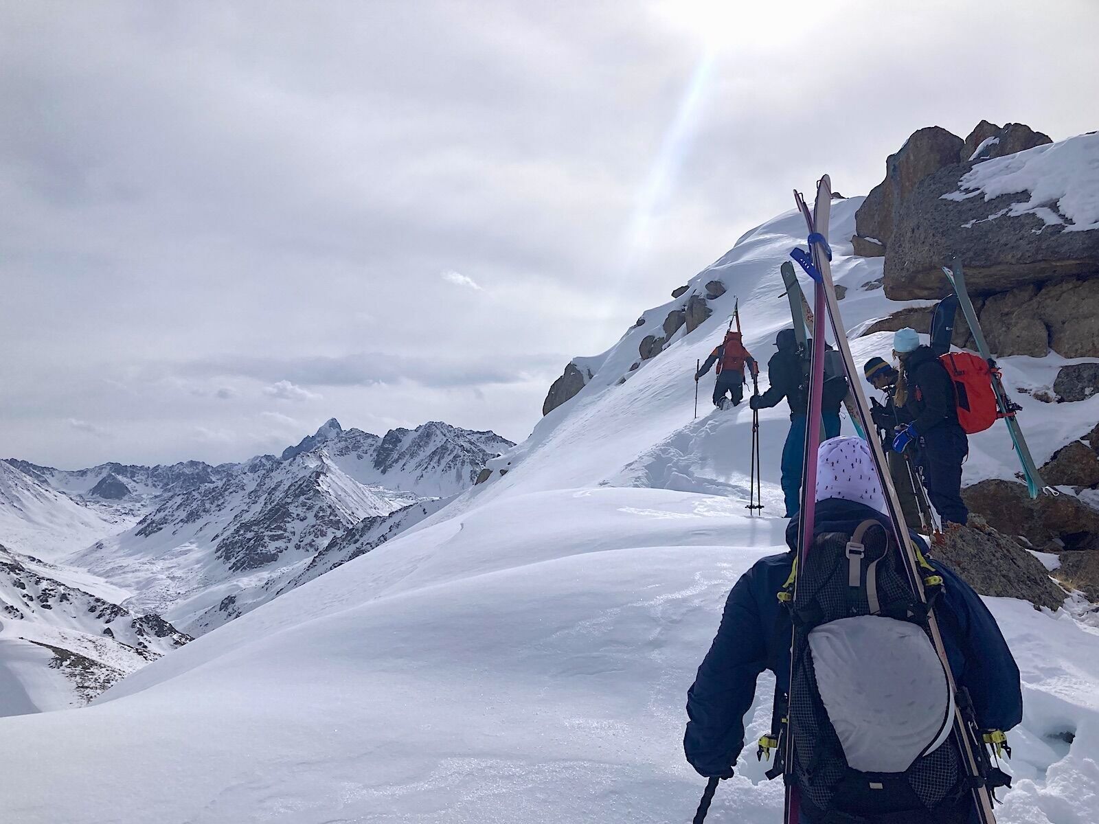 skiers bootpacking to top of mountain