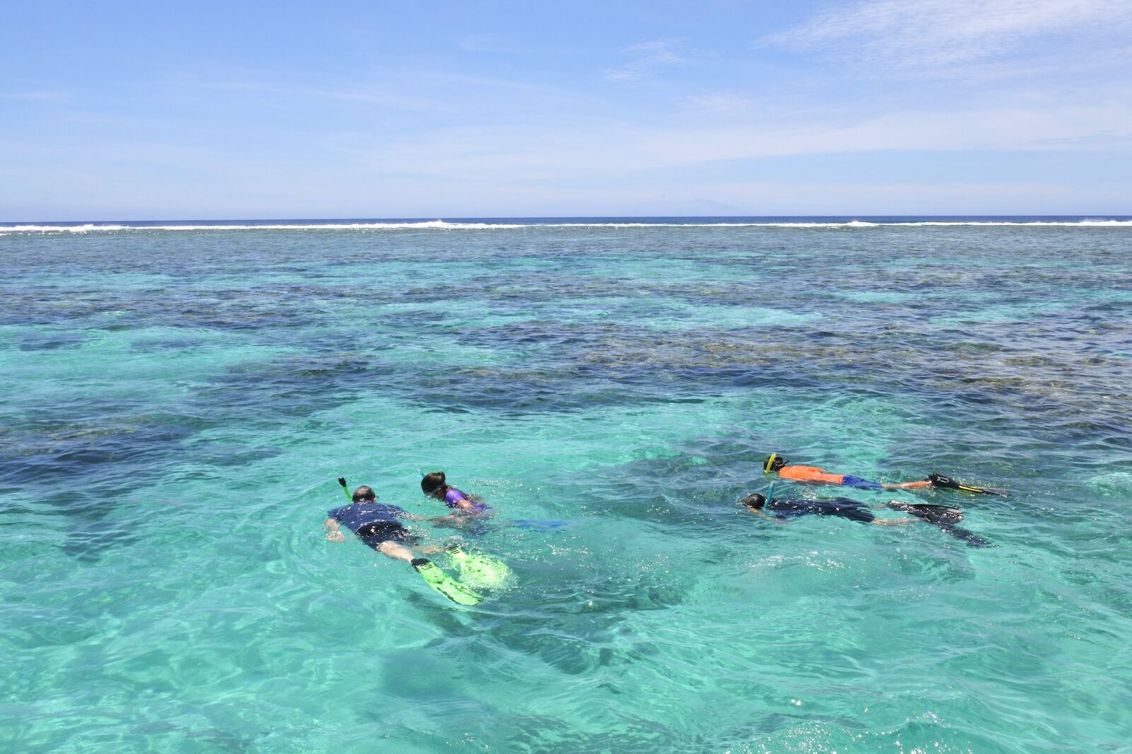 snorklers swimming over a reef