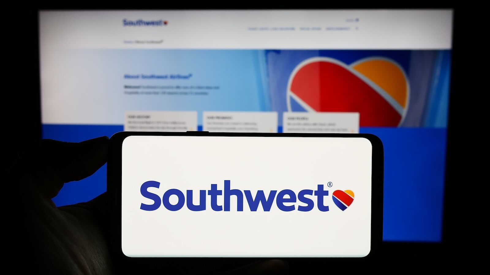 southwest logo on phone in front of southwest website on computer