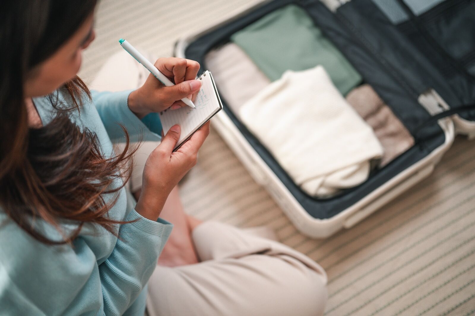 woman taking notes while packing