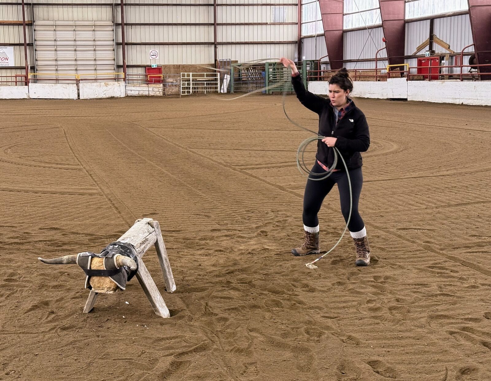 woman roping stationary bull in ring