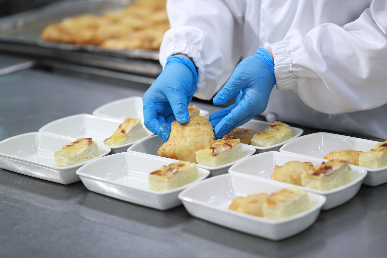 gloved food worker preparing in-flight meals