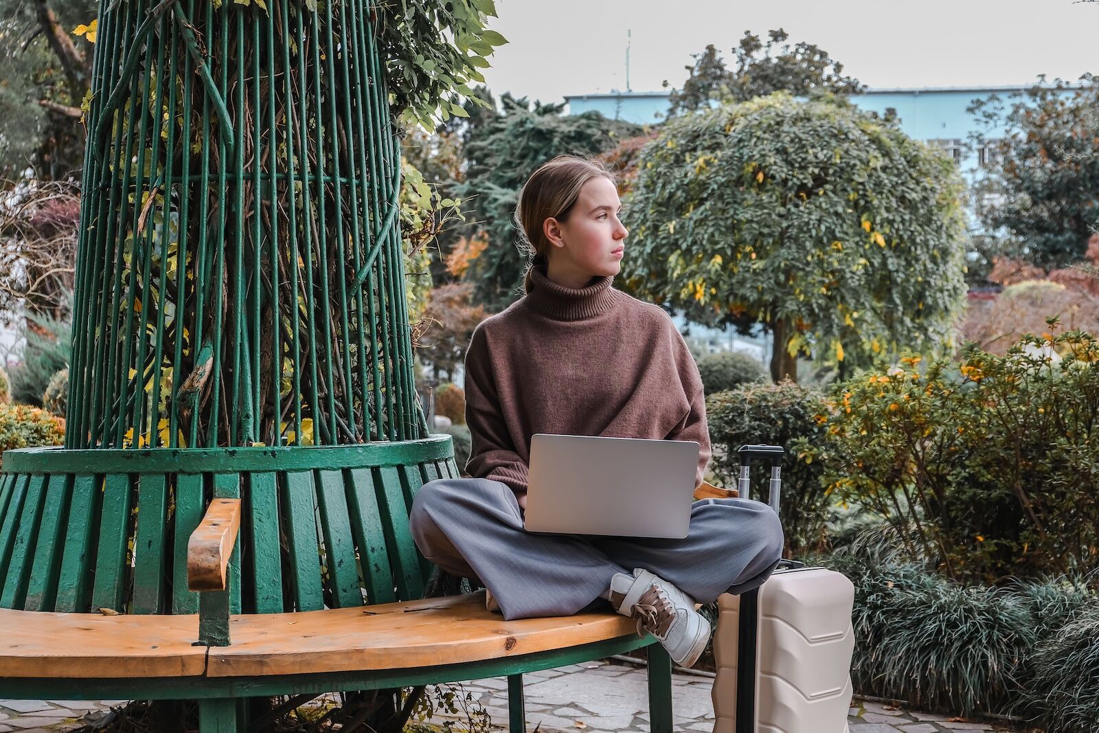 digital nomad working on laptop on bench