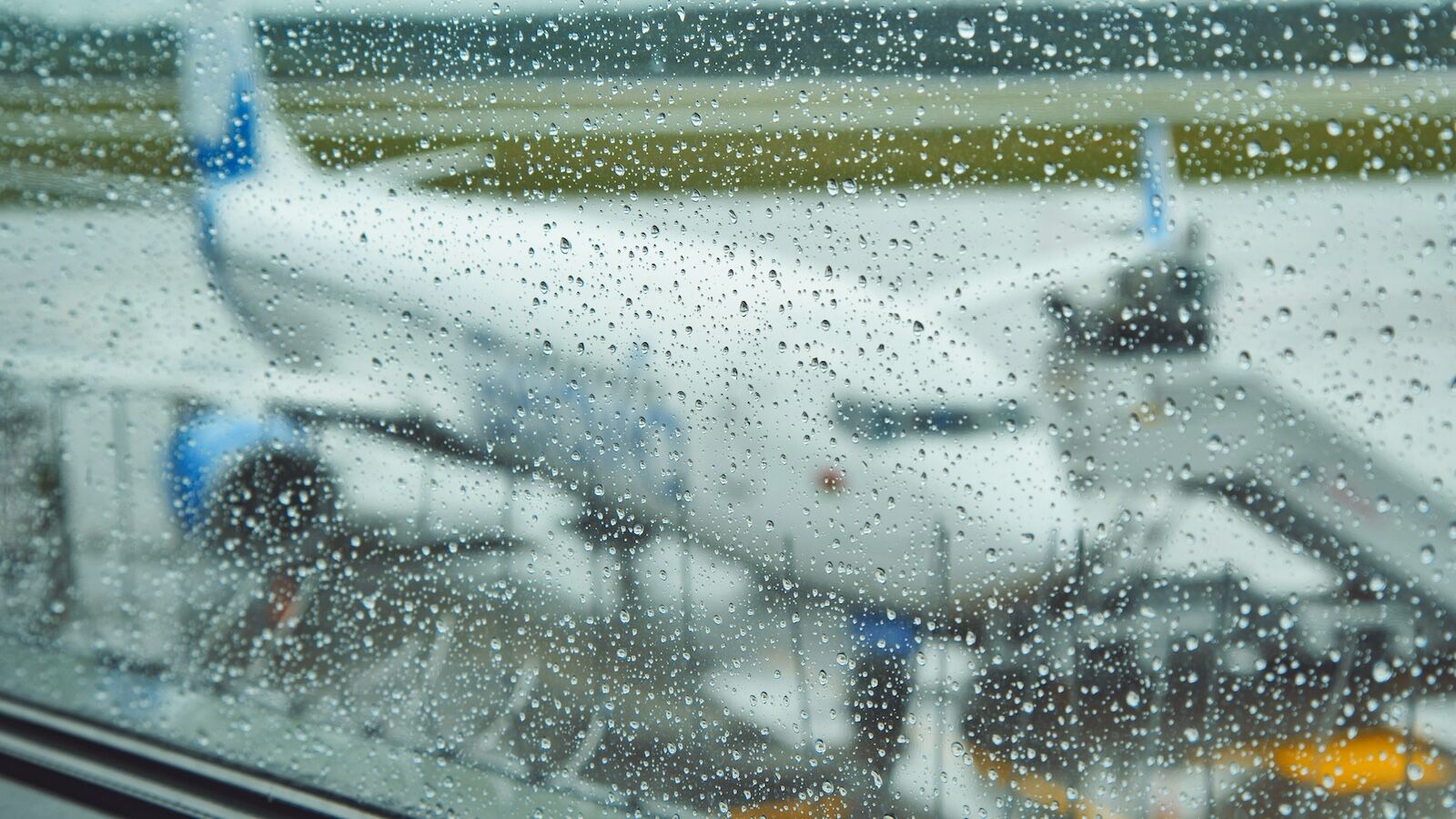 plane through rain-covered window
