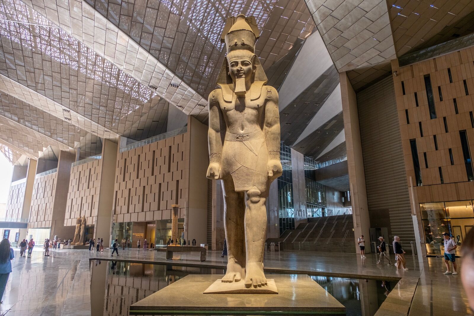 GIZA, EGYPT - OCTOBER 2, 2025: Close-up of the colossal statue of Ramses II in the Grand Hall of the Grand Egyptian Museum (GEM). The ancient figure is dramatically framed by the modern, angular