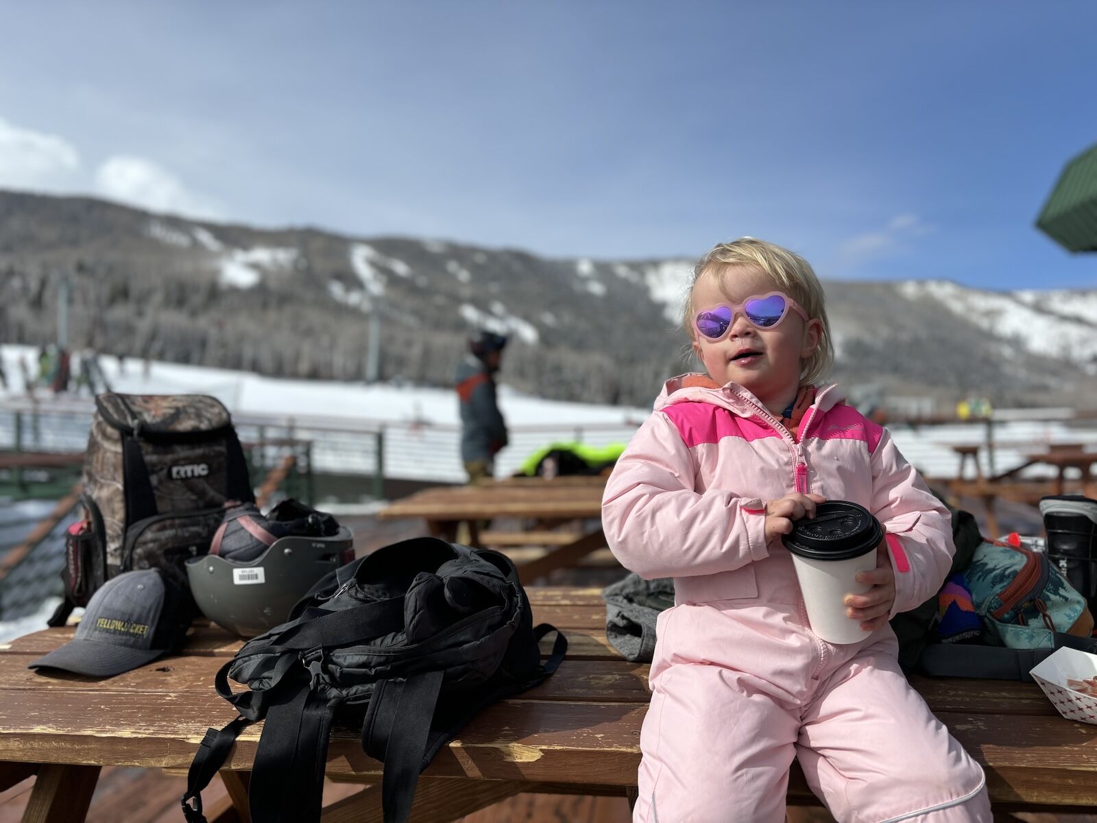 little girl sits on table in ski gear