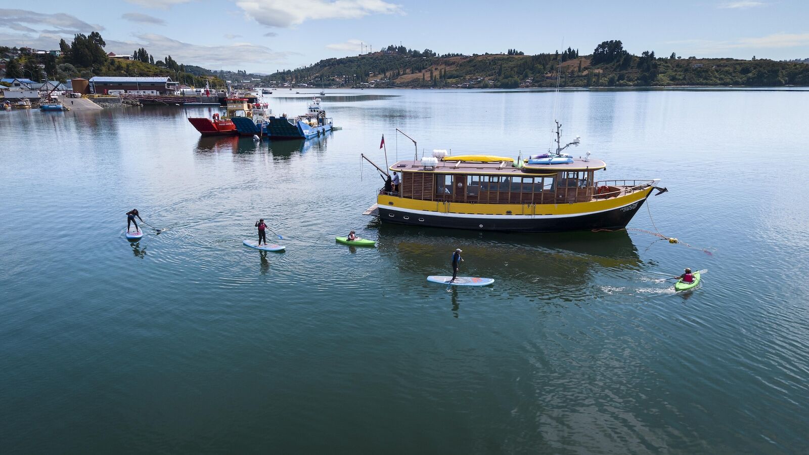 boat and paddleboarders near Refugia Chilo&eacute;
