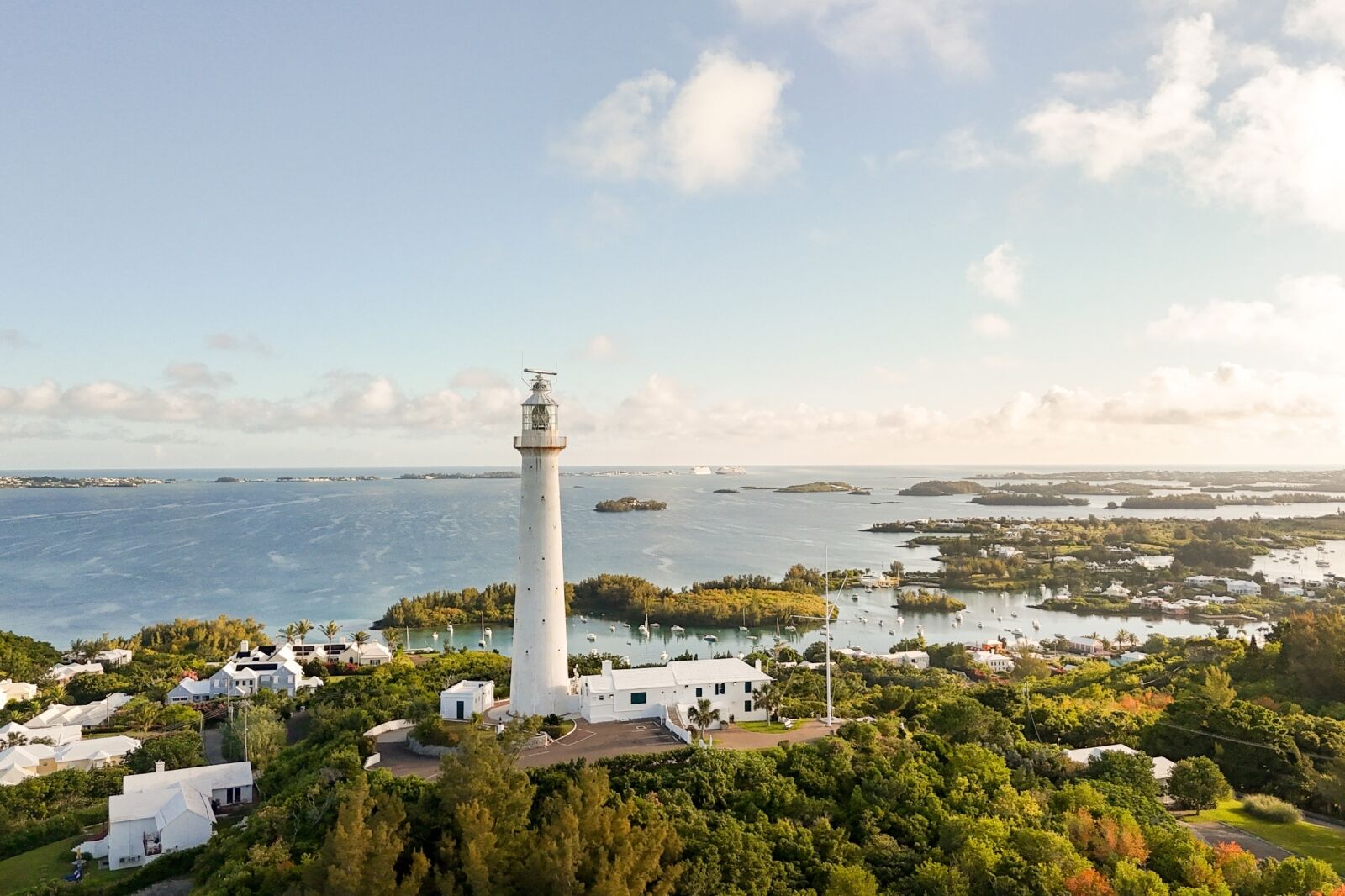 Southampton, Bermuda - June 11 2025: Aerial view of Gibb&rsquo;s Hill Lighthouse surrounded by greenery with the Atlantic Ocean in the background.