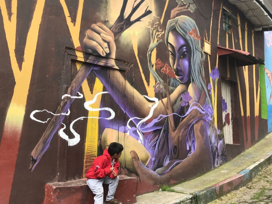 Street art in Bogota, with a little kid looking at the mural